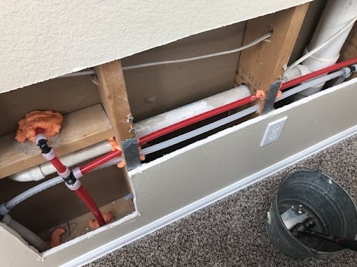 Professional PEX-A whole-home repipe inside drywall stud cavity performed by Just Plumbing in Arvada CO